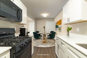 A kitchen with white cabinets and a black stove top oven